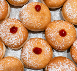 Fresh donuts  with jelly  at the bakery display for Hanukkah celebration. Selective focus.