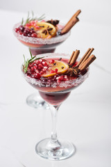 selective focus of christmas cocktail with orange, pomegranate, cinnamon