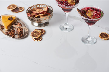 christmas cocktails with orange, pomegranate, cinnamon, apple pie and dry apples