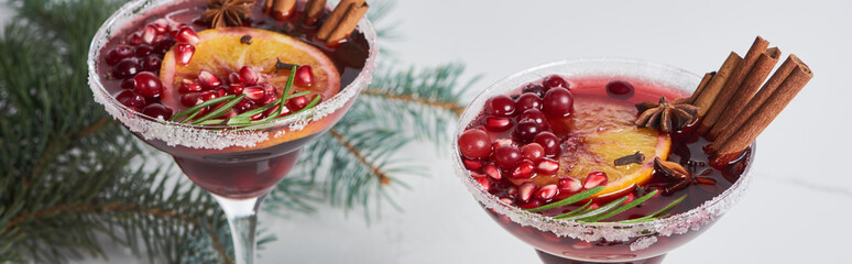 panoramic shot of christmas cocktails with orange, pomegranate and cinnamon