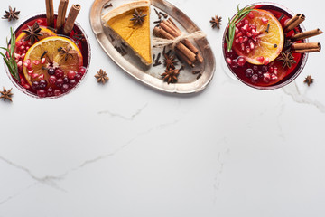 top view of christmas cocktails with orange, pomegranate, cinnamon and pie on tray