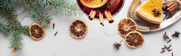 panoramic shot of christmas cocktail with orange, pomegranate, cinnamon and pie on tray