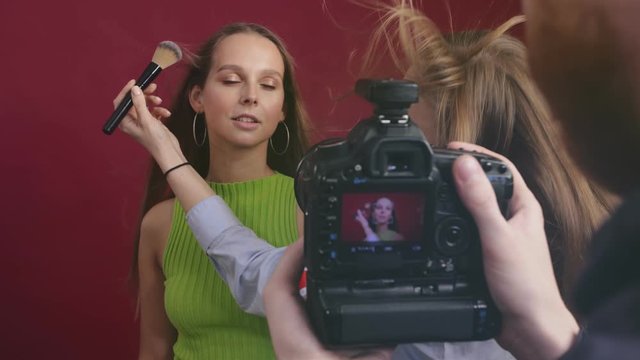 Make-up artist applying powder on model's face