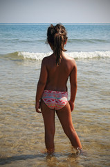 Girl on her back looking at the sea in summer