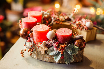 Hand made Christmas wreath with red advent candles ring at florist's workshop table