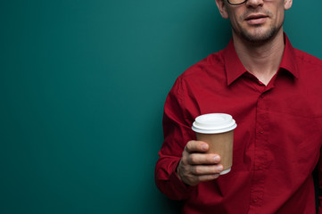 Close-up - young man holding a glass of coffee
