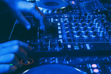Fototapeta na wymiar DJ mixes the track in the nightclub at party
