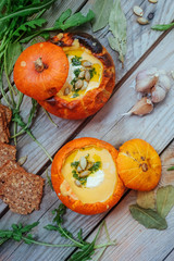 Pumpkin soup served in a small pumpkins. autumn dish. Still life, top view,