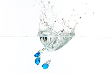 Beautiful and cool splashes of water from falling into it blue transparent crystals