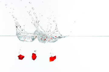 Beautiful and cool splashes of water from falling into it red transparent crystals
