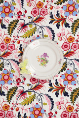 flower plate hidden on a flowery fabric with a yellow butterfly