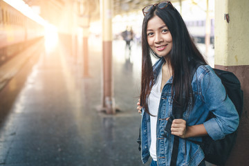 Portrait of young asian woman smiling  and waiting at train station. Travel concept.