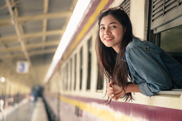 Portrait of young asian woman smiling in train at train station. Travel concept.
