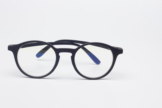 Gafas cl&aacute;sicas con cristales graduados, montura de pl&aacute;stico de color negro, sobre fondo negro