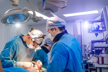 Process of surgery operation using laparoscopic equipment. Two surgeons in operating room with...