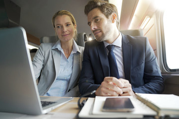 two colleagues working on a train