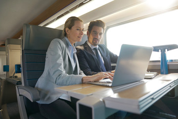two colleagues working on a train