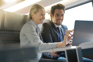 two colleagues working on a train