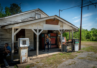 Asian woman  and teen girl standing in front of abandoned gas station in Virginia