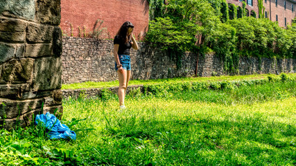 Teen girl standing in grass and looking down
