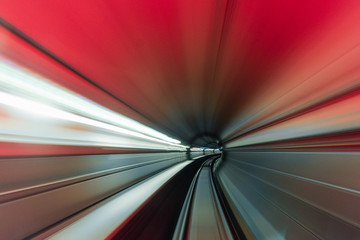 High speed curved motion to the right inside a tunnel with red light.