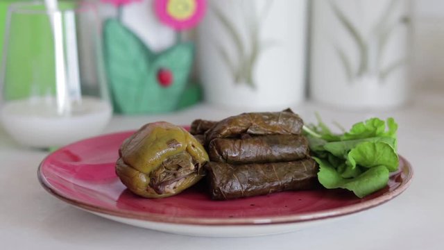 Traditional Turkish foods, dolma and sarma. Pouring ayran into glass.