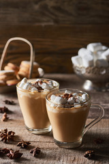 cacao with marshmallow in mugs near anise on wooden table