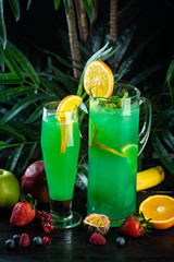 Curacao lemonade in a glass and jug decorated with an orange slice