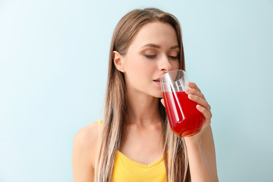 Woman drinking healthy juice on light background. Diet concept