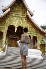 Fototapeta premium A young woman at The Temple of Wat Ho Pha Bang in Luang Prabang, Laos
