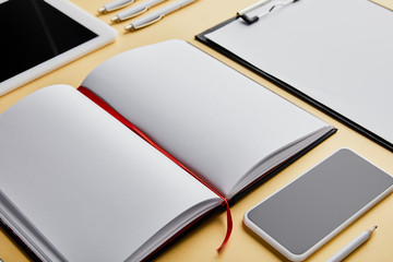 notebook, clipboard, pens, pencil, smartphone and digital tablet with copy space