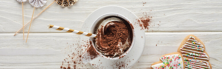 top view of Christmas cacao in mug with decoration and cookies on white wooden table, panoramic shot