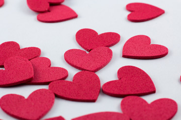 Red crafting foam hearts in white background. Decor hearts by cutting from red crafting foam