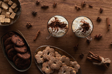 top view of Christmas cacao near cookies, anise, cinnamon and brown sugar on wooden table