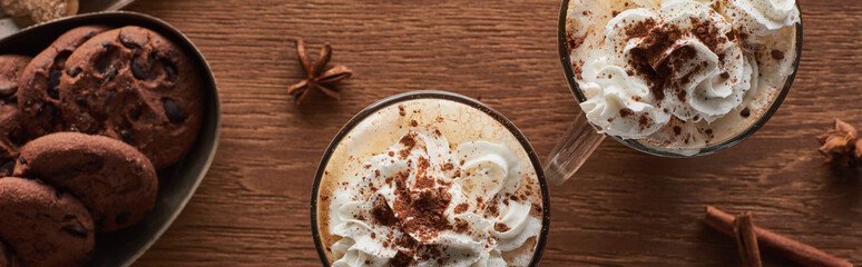 panoramic shot of Christmas cacao with whipped cream on wooden table with biscuits