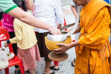 Buddhist monks are given food offering from people for End of Buddhist Lent Day