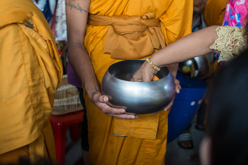 Buddhist monks are given food offering from people for End of Buddhist Lent Day