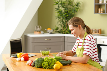 Beautiful young woman cooking in kitchen