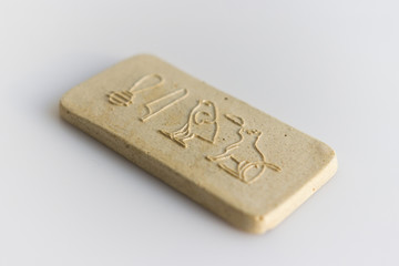 clay tablet with the inscription cat in ancient egyptian. modern handwork. hieroglyph cat