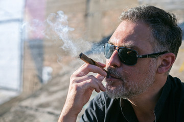 middle age man smoking cigar outdoors