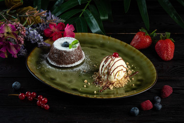 chocolate flan and scoop of ice cream in a green plate