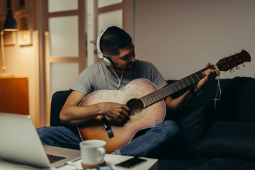 man playing guitar at his home