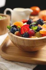 Bowl with tasty fruit salad on table