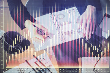 Multi exposure of hands making notes with forex chart huds. Stock market concept.