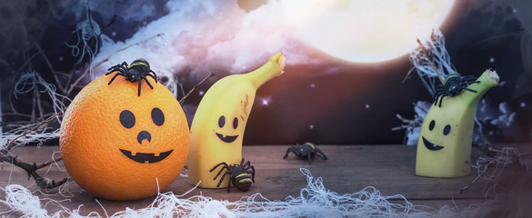 Halloween mandarin on a dark spooky forest with blue fog.Halloween Background