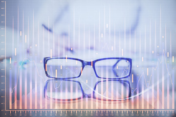 Hand taking notes in notepad. Forex chart holograms in front. Concept of research. Double exposure