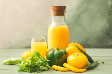 Glass and bottle of fresh vegetable juice on table