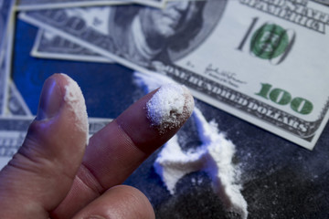 cocaine, dollars, pills and syringe on the table