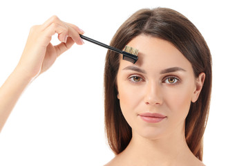 Fototapeta premium Beautiful young woman with makeup brush on white background
