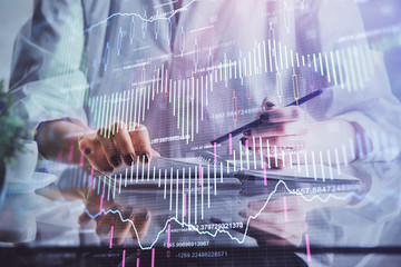 Financial forex graph drawn over hands taking notes background. Concept of research. Double exposure